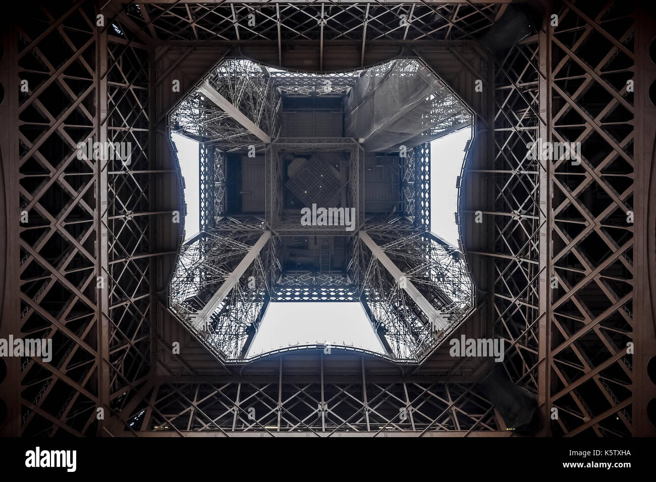 Symmetrical view from under the eiffel tower, showcasing its intricate iron lattice structure. Stock Photo