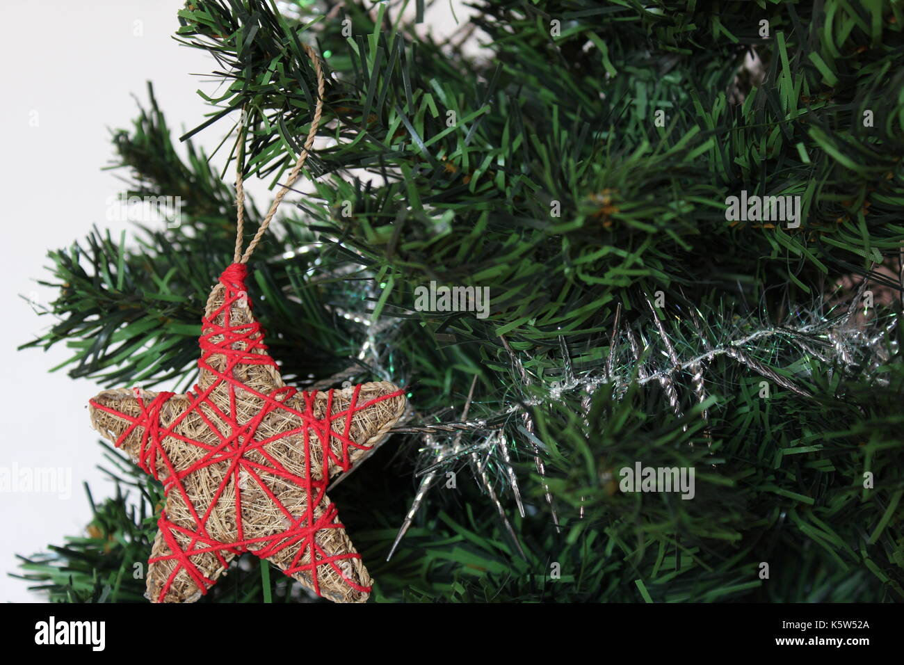 Handmade star ornament on a Christmas tree with white background ...