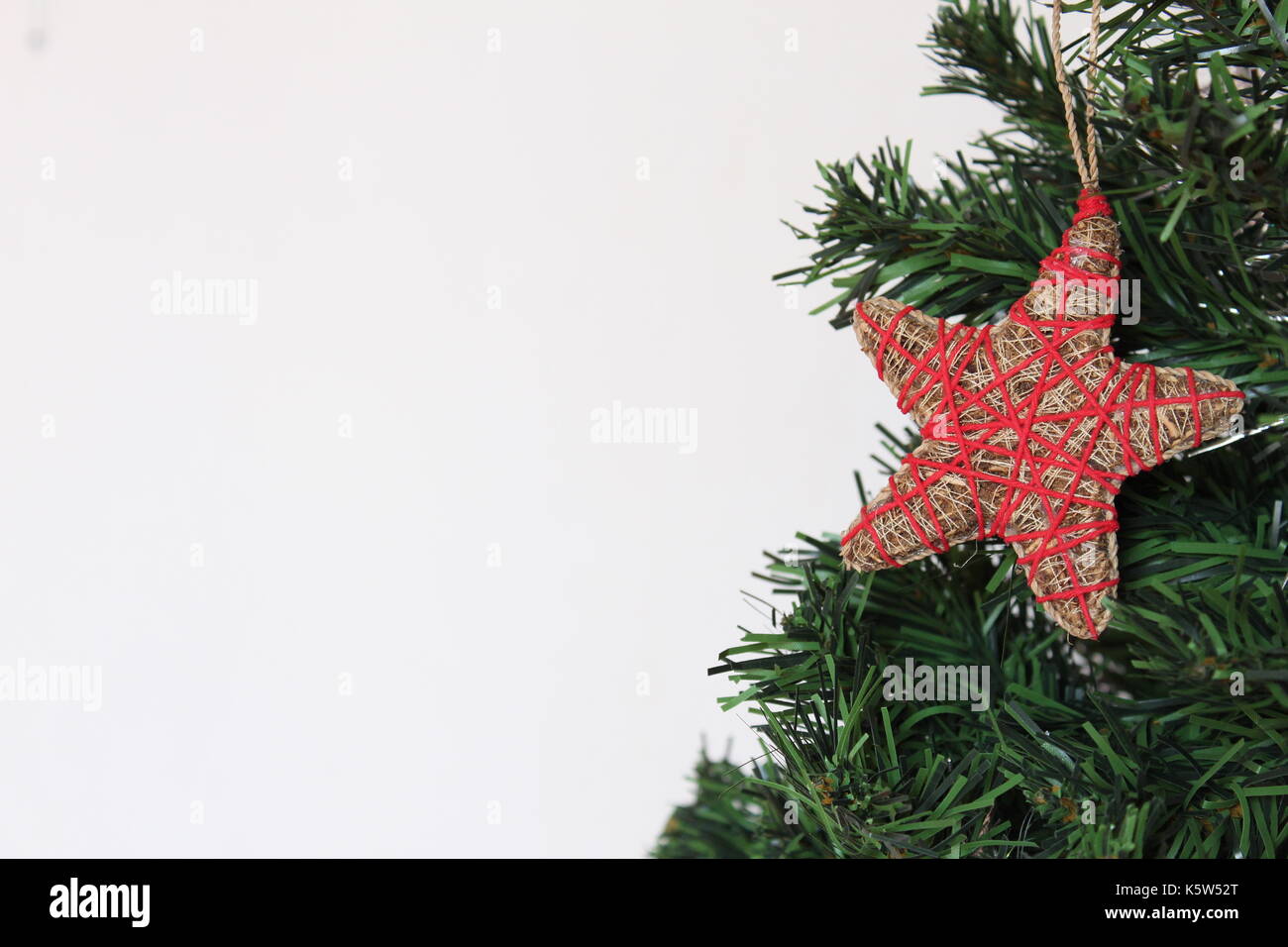 Handmade star ornament on a Christmas tree with white background ...