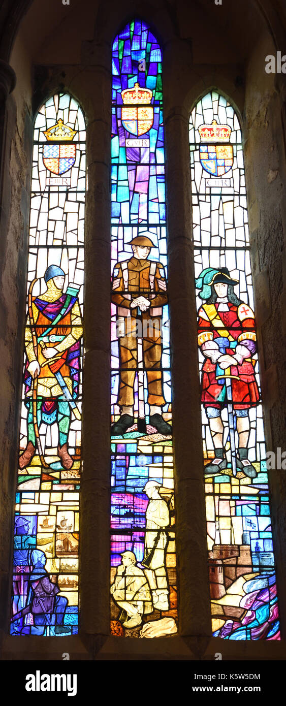 Twentieth century stained glass windows in the chancel of the Royal Garrison Church depict events in the history of the church. Stock Photo