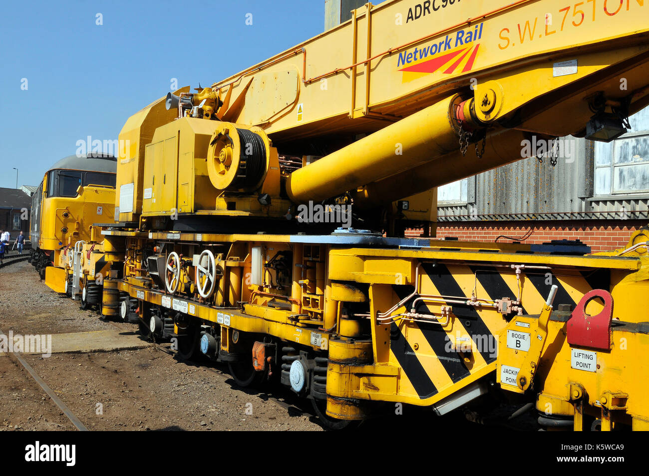 A large railway crane 75 tons in yellow livery network rail engineering machinery and works heavy lifting infrastructure projects and maintenance work Stock Photo