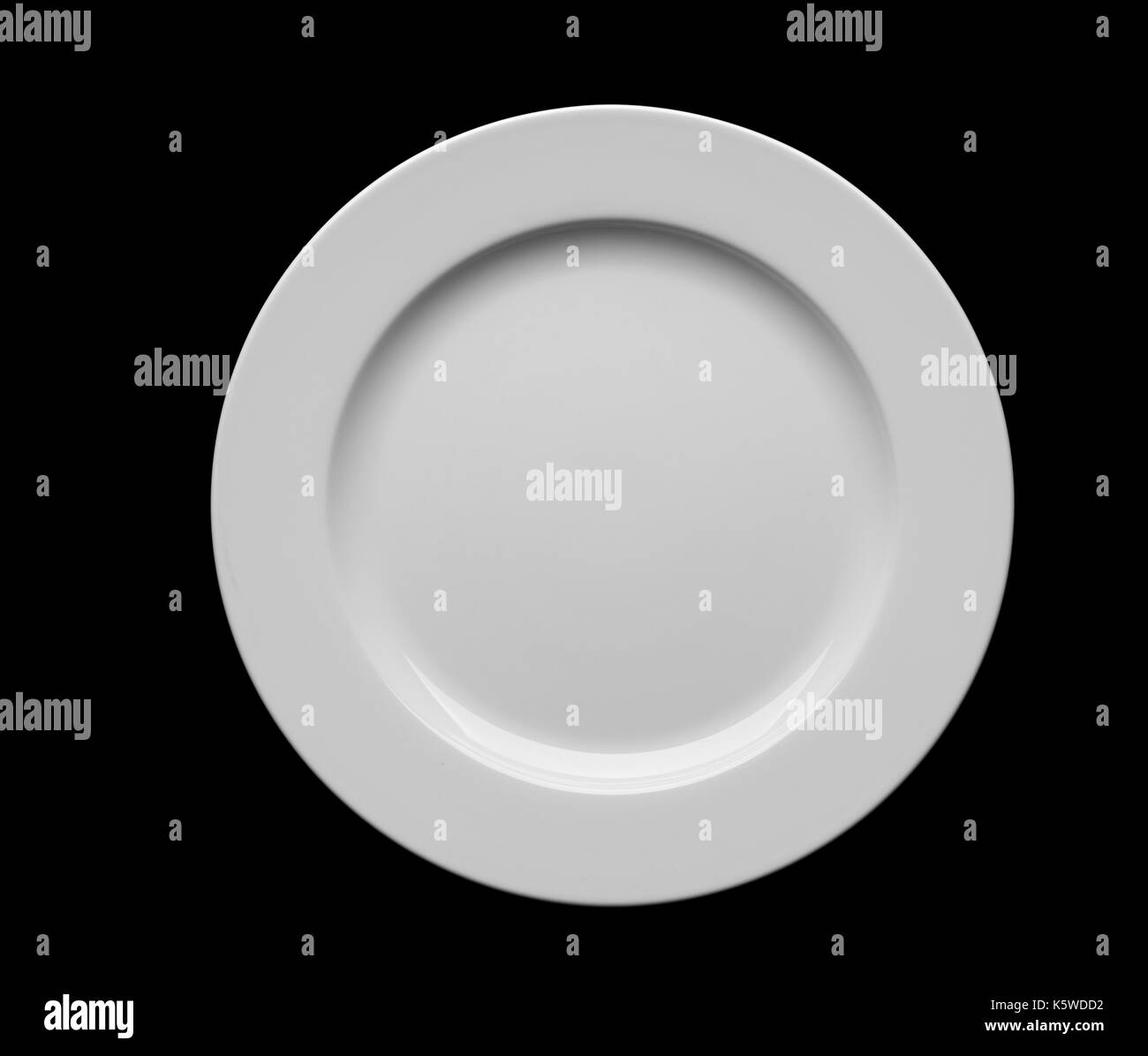 Empty white plate isolated on black background. Stock Photo