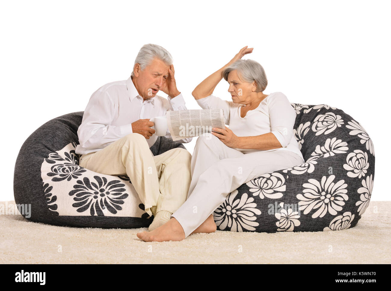 Couple sitting in armchairs with newspaper Stock Photo