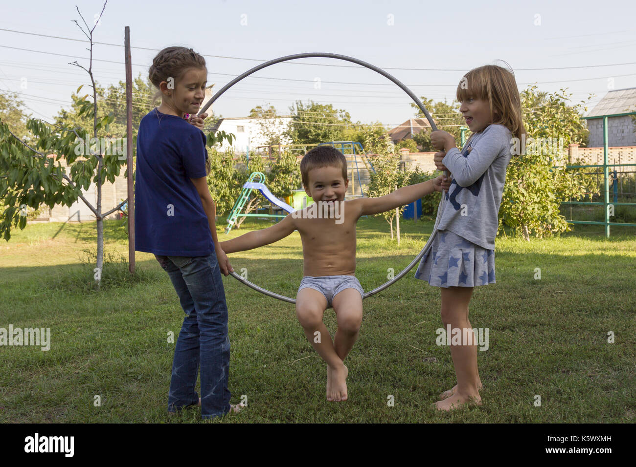 Three children play in the hoop park Stock Photo