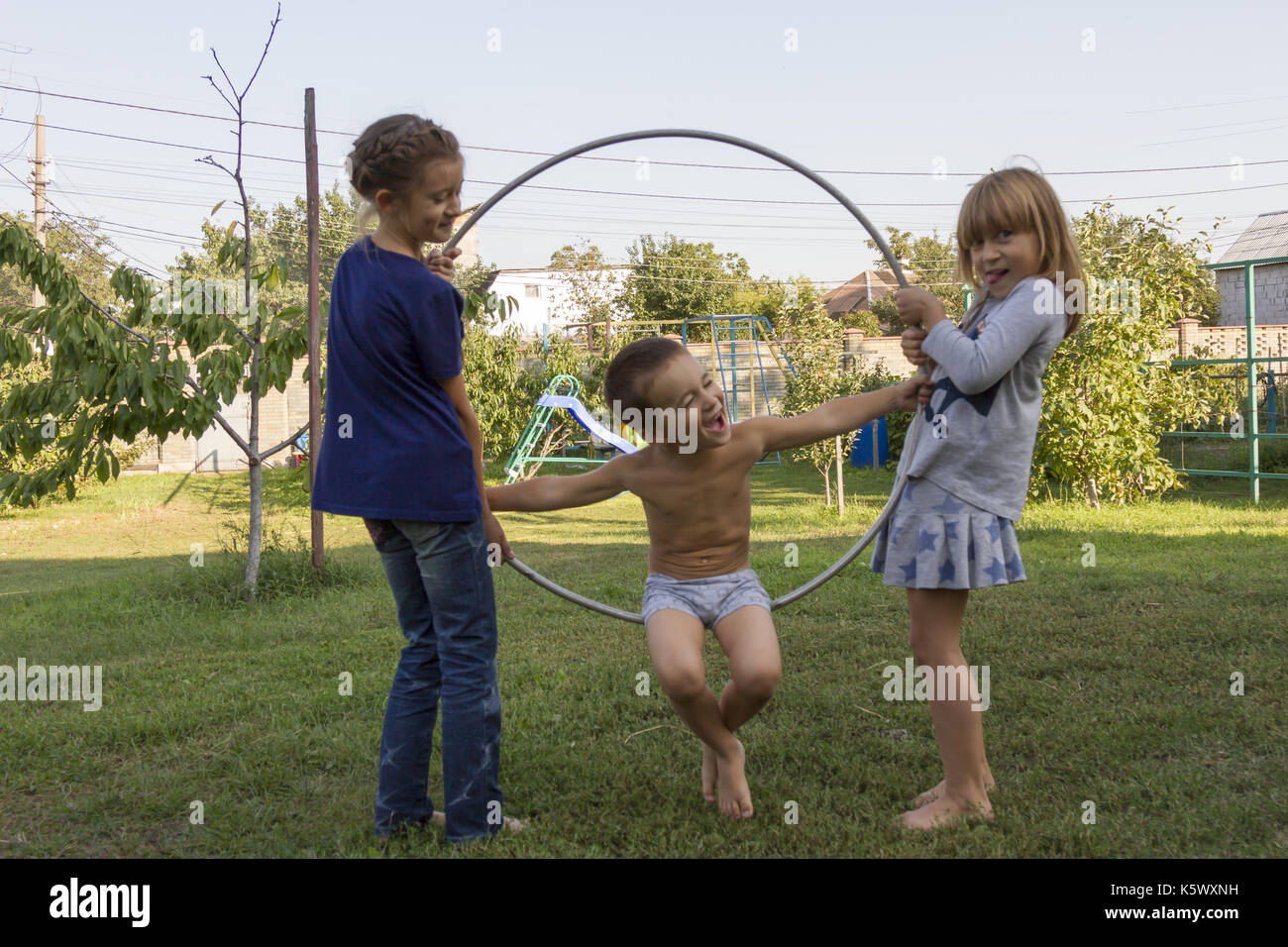 Three children play in the hoop park Stock Photo