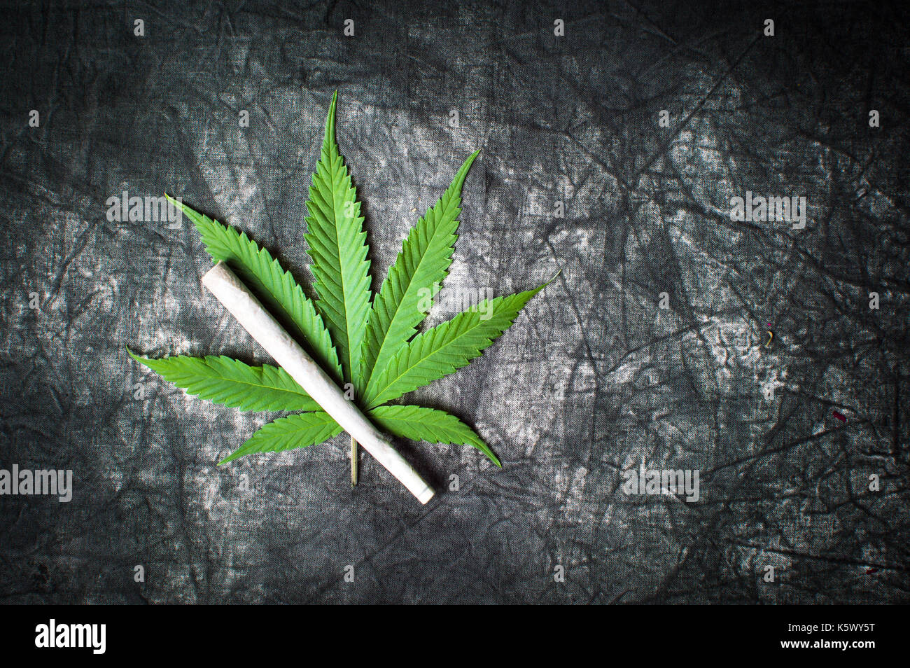 Marijuana leaf and joint on a dark textured background Stock Photo Alamy