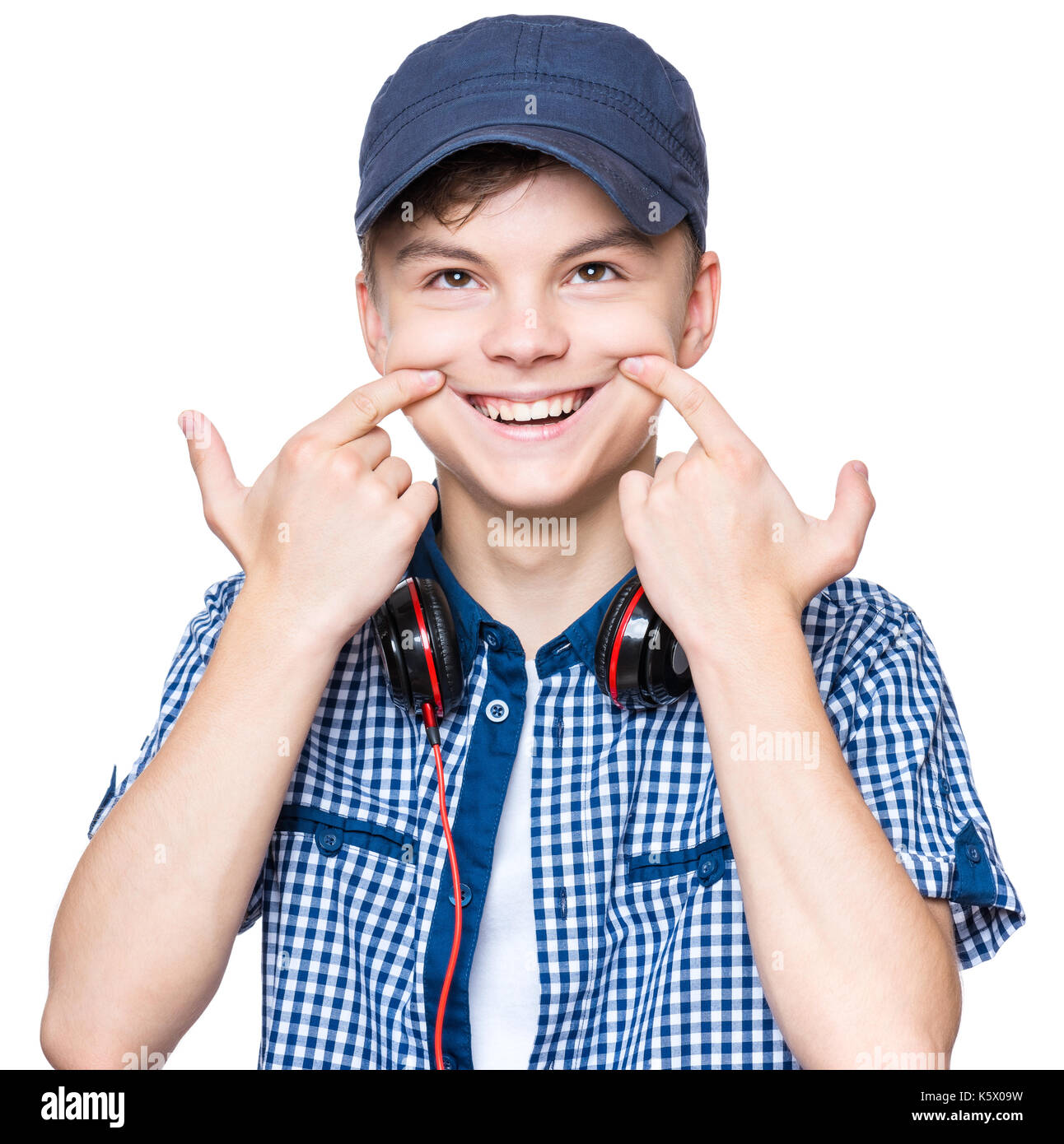 Silly boy making grimace. Child with wry smile, isolated on white background. Emotional portrait of caucasian teenager looking at up. Stock Photo