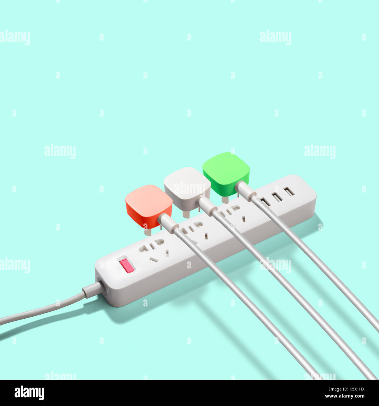 Three electrical plugs connected to power strip Stock Photo