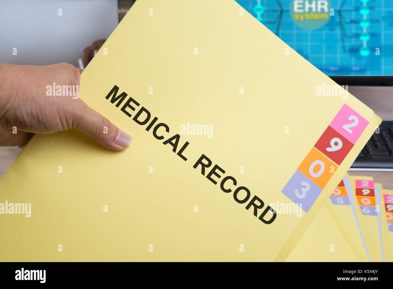Yellow medical record folder in someone hand. Stock Photo