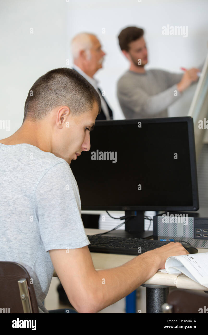 Student In Front Of A Computer male student sitting in front of a computer in classroom Stock Photo ...