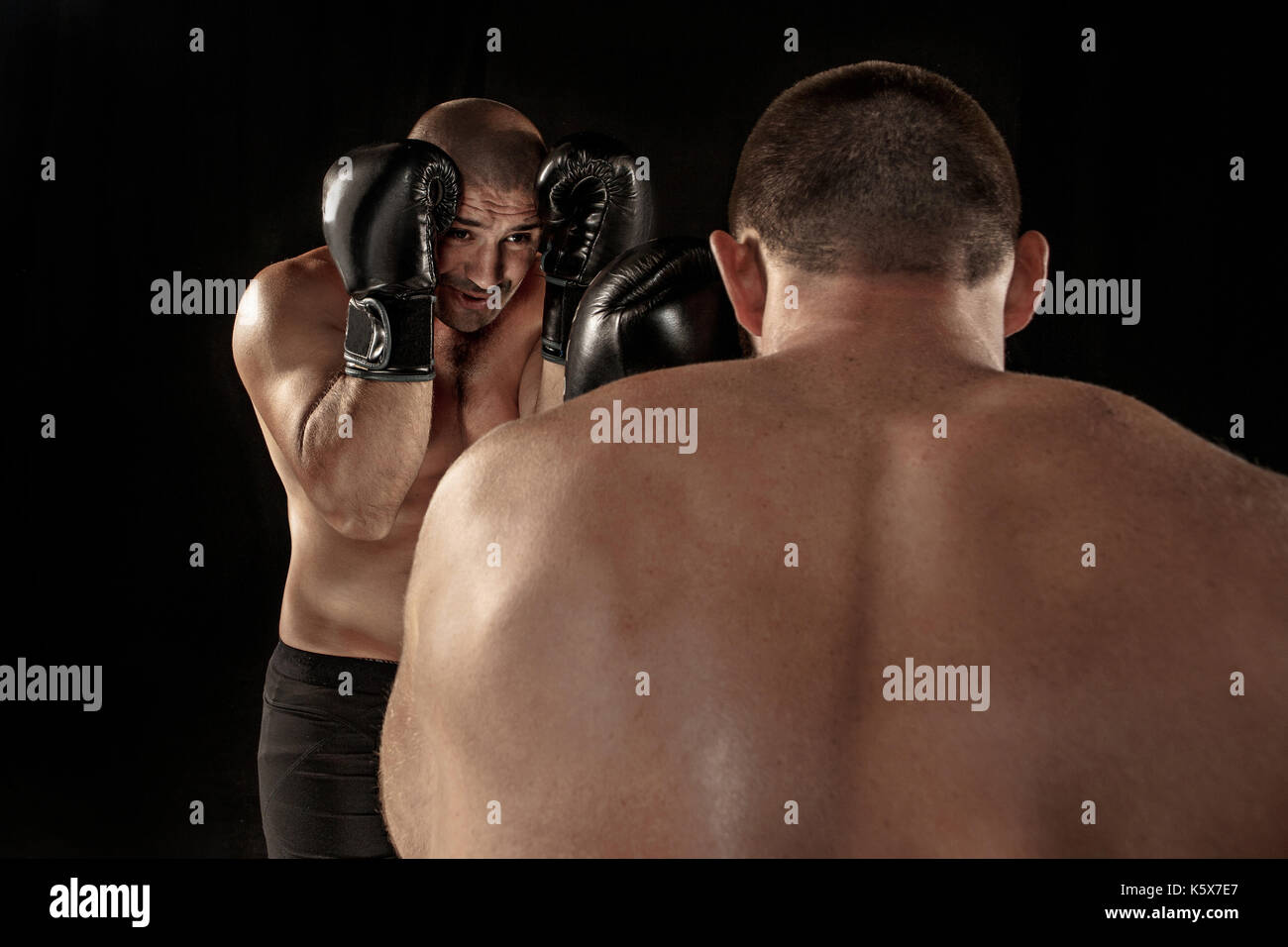Two muscular men fighting, bodybuilders punching each other, training