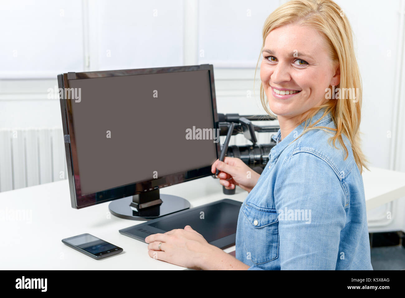 Blonde Computer Program Young blonde graphic designer working on computer using tablet Stock ...