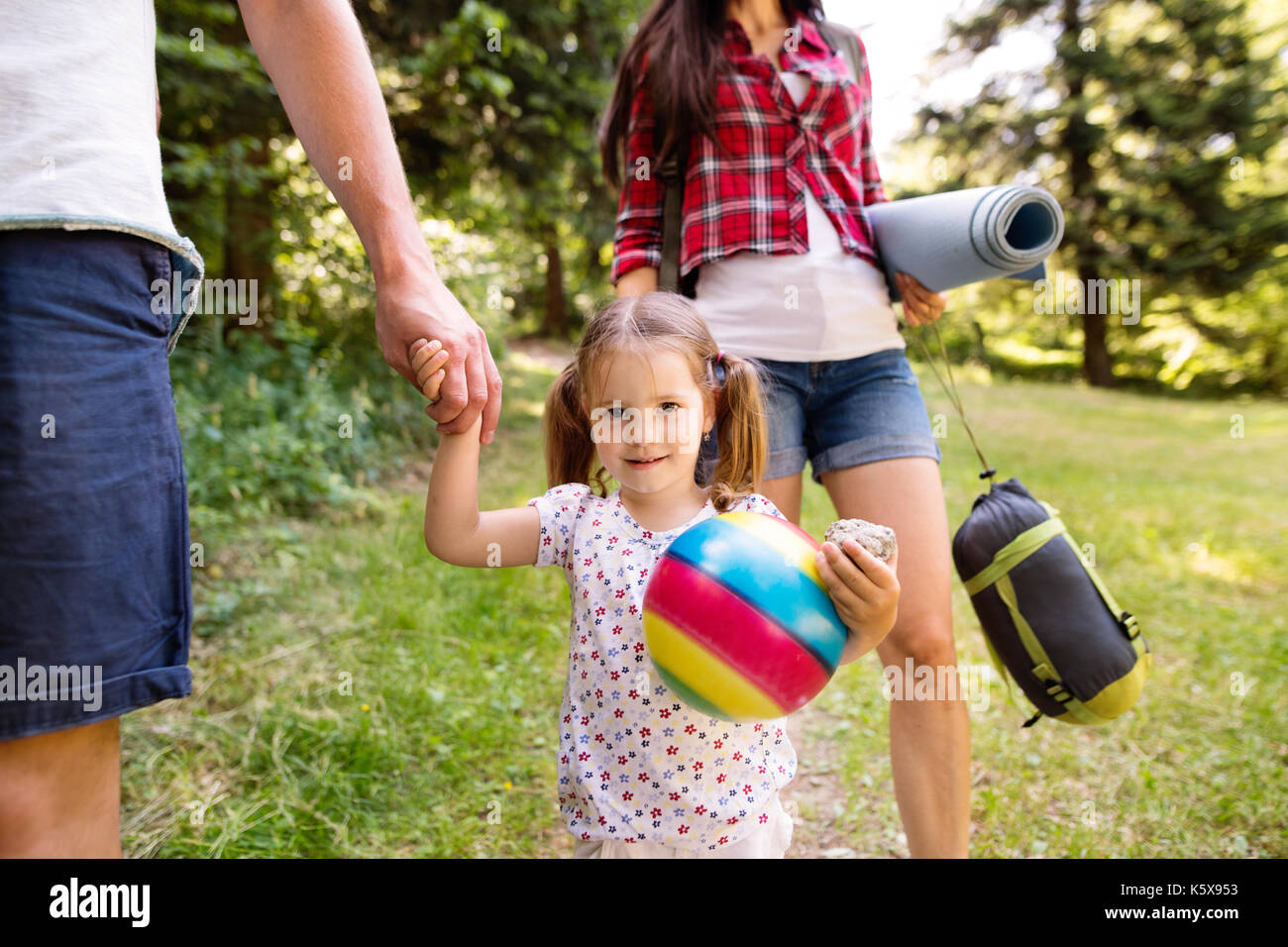 Beautiful young family with daughter camping in forest. Stock Photo