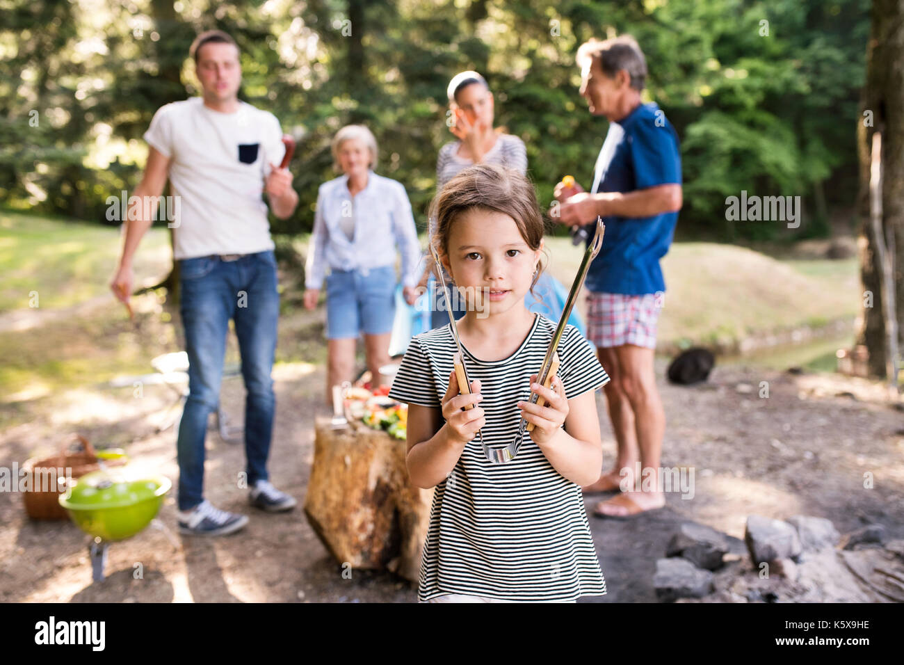 Beautiful family camping in forest, eating together. Stock Photo