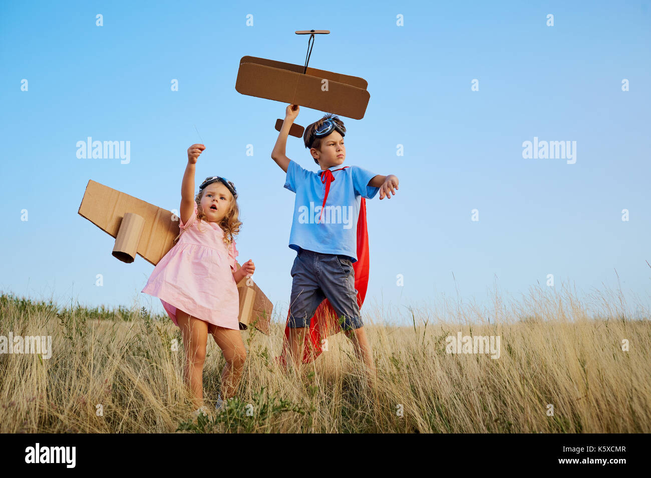 Brother and sister in suits of superhero pilots are walking in n Stock Photo