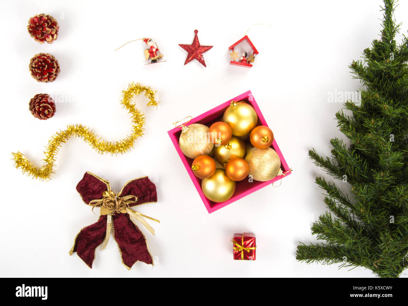 High angle view of a collection of Christmas ornaments and a plastic pine tree on a white background Stock Photo