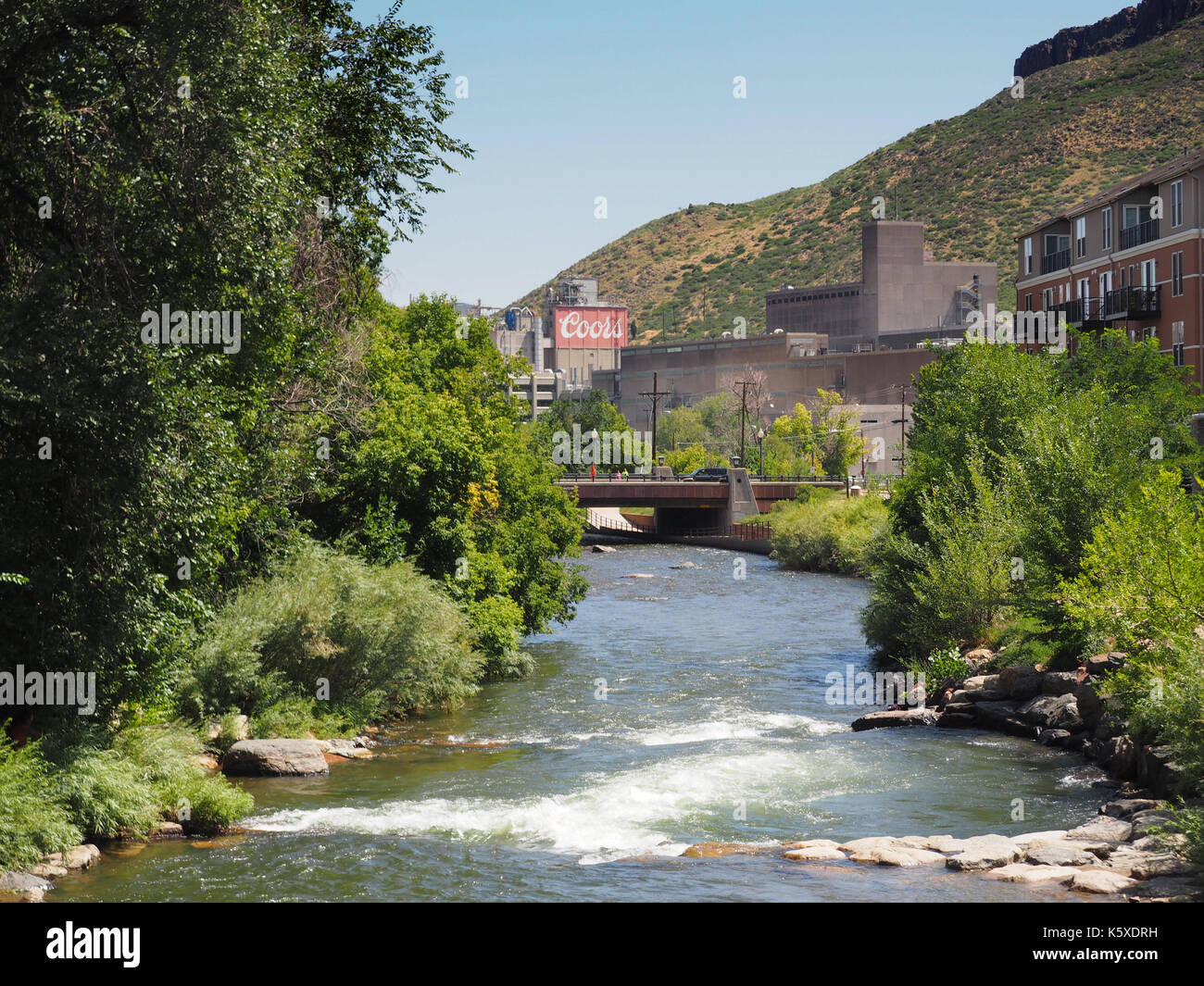 Golden, CO - August 12:  The Coors brewery in Golden, Colorado, that is the largest single brewery facility in the world.   The Clear Creek runs throu Stock Photo