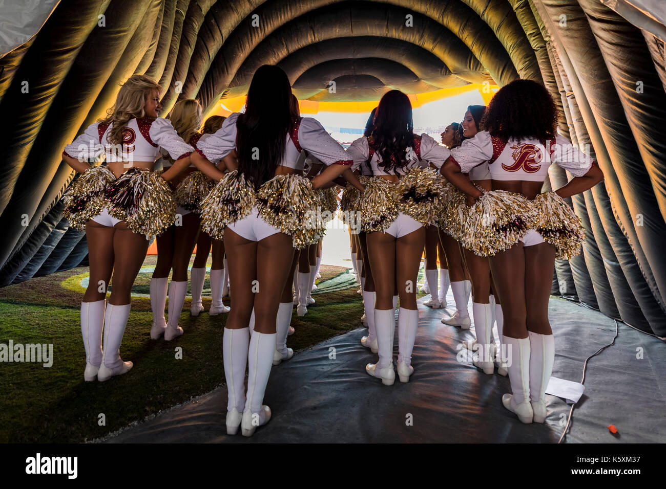 A cheerleader shakes her pom-poms smiles and encourages action