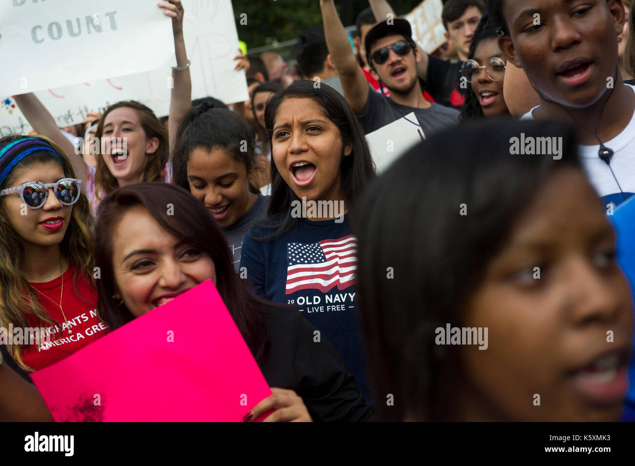 A young lady chanting anti Trump slogans during the protest. A small crowd gathers in front of the White House to protest President Donald Trump's intention to rescind the Deferred Action for Childhood Arrivals Act, also known as DACA or the Dream Act. Deferred Action for Childhood Arrivals (DACA) is a kind of administrative relief from deportation. The purpose of DACA is to protect eligible immigrant youth who came to the United States when they were children from deportation. DACA gives young undocumented immigrants: 1) protection from deportation, and 2) a work permit. The program expires a Stock Photo