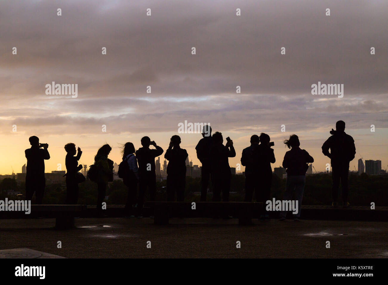 London, UK. 11th Sep, 2017. London, September 11 2017. A group of people admire the London skyline from the summit of Primrose Hill as a new day breaks over the city. Credit: Paul Davey/Alamy Live News Stock Photo