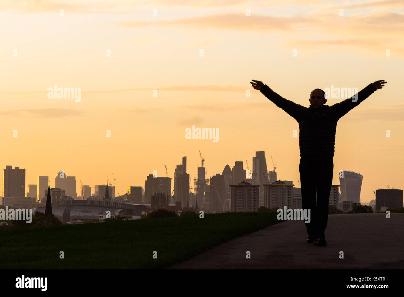 London, UK. 11th Sep, 2017. London, September 11 2017. A man exercises against the backdrop of the London skyline as a new day breaks over the city. Credit: Paul Davey/Alamy Live News Stock Photo