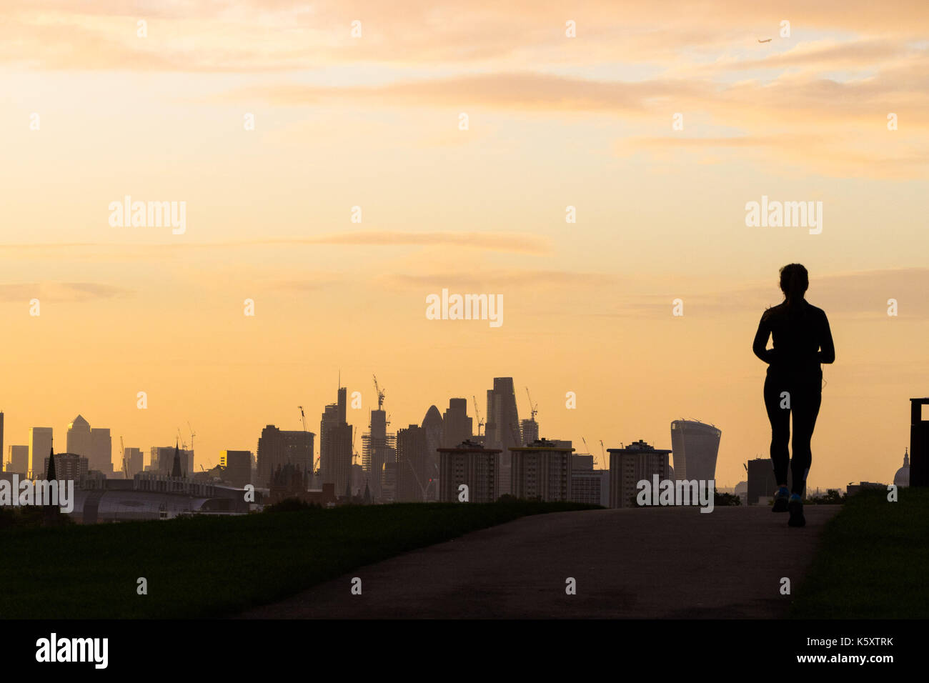 London, UK. 11th Sep, 2017. London, September 11 2017. A runner reaches the summit of Primrose Hill creating a silhouette against the London skyline as a new day breaks over the city. Credit: Paul Davey/Alamy Live News Stock Photo