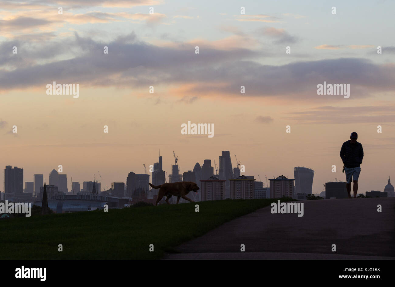 London, UK. 11th Sep, 2017. London, September 11 2017. A dog walker in silhouette against the London skyline as a new day breaks over the city. Credit: Paul Davey/Alamy Live News Stock Photo