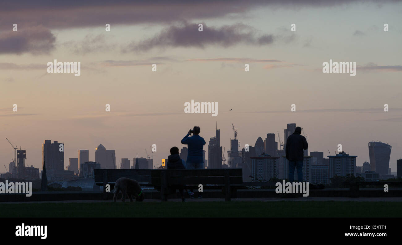 London, UK. 11th Sep, 2017. London, September 11 2017. Early morning walkers and runners pause on Primrose Hill to admire the London skyline as a new day breaks over the city. Credit: Paul Davey/Alamy Live News Stock Photo