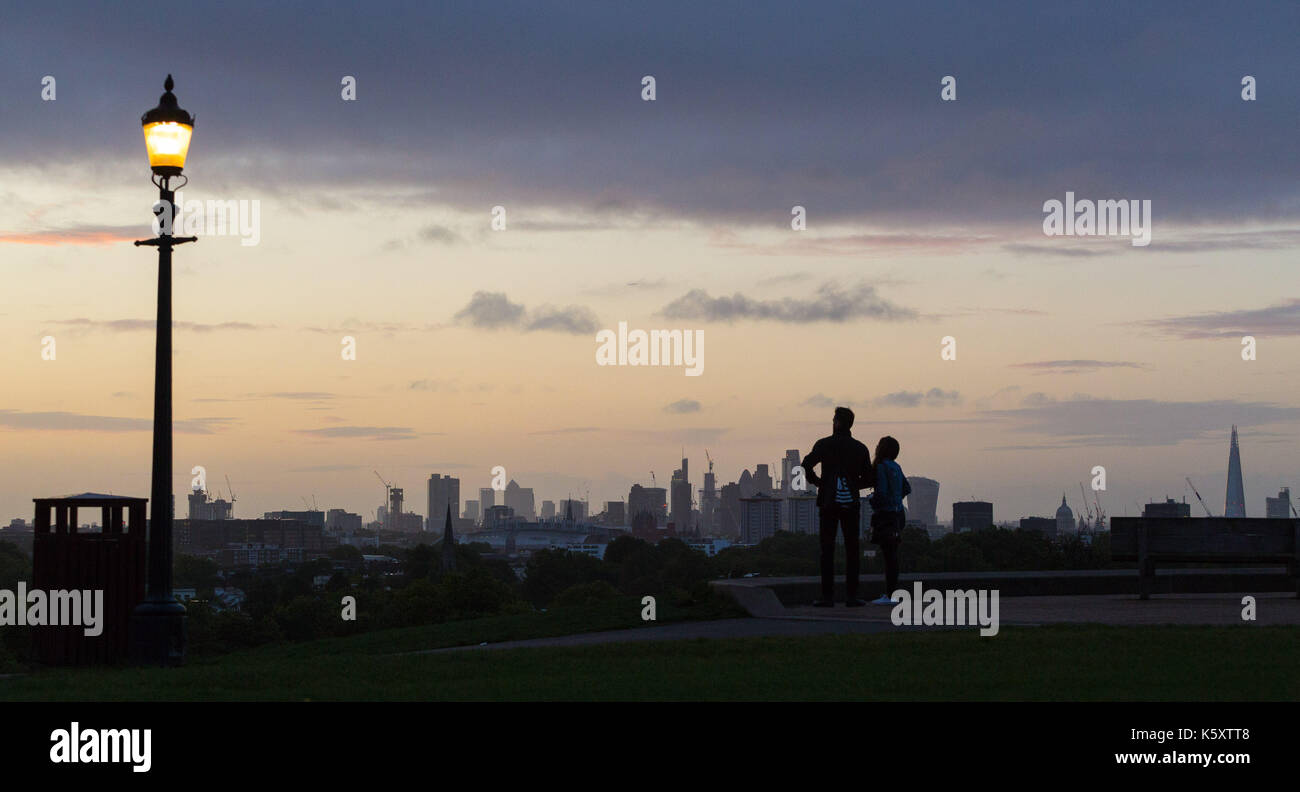 London, UK. 11th Sep, 2017. London, September 11 2017. A couple wait for the sun to rise above the London skyline as a new day breaks over the city. Credit: Paul Davey/Alamy Live News Stock Photo