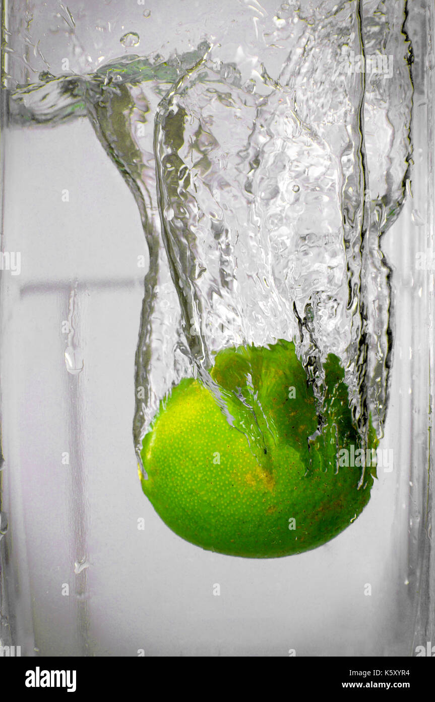 Lime falling into water and splashing Stock Photo
