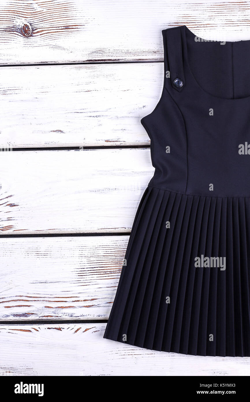 Girls black pleated dress for school. Classic black school uniform dress  for girls on wooden background. Childrens school outfit Stock Photo - Alamy