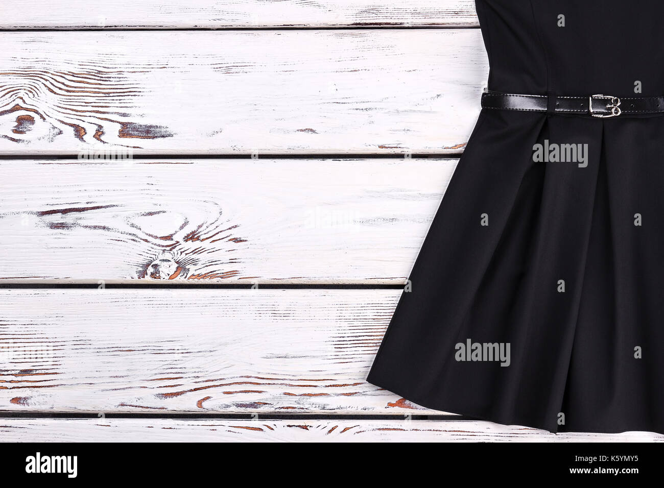 Cropped image of vintage black dress. Classical short a-line dress with  belt for little girls on white wooden background, copy space. Little black  ret Stock Photo - Alamy