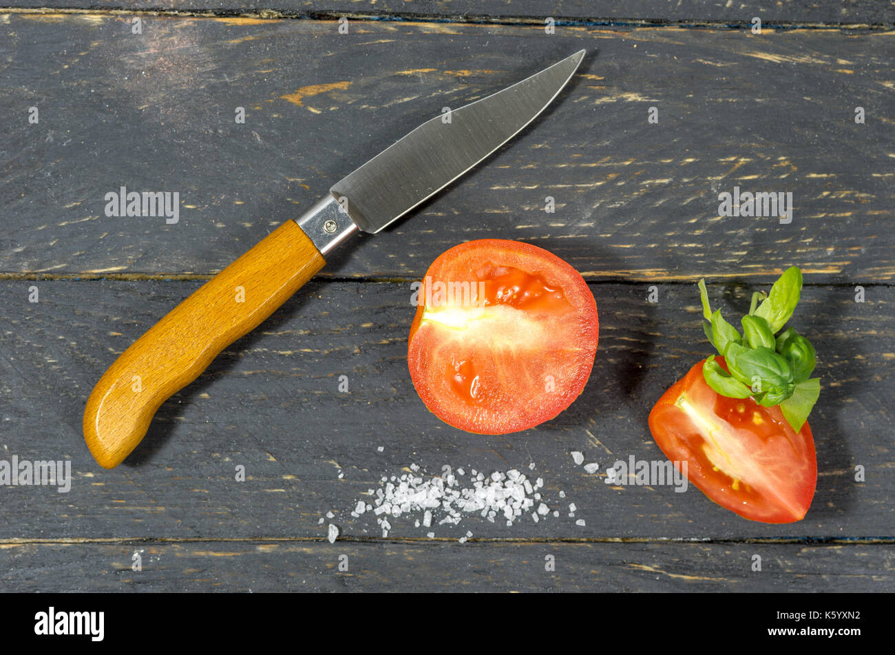 Cutting tomatoes with a sharp pocket knife. Black background Stock Photo Alamy