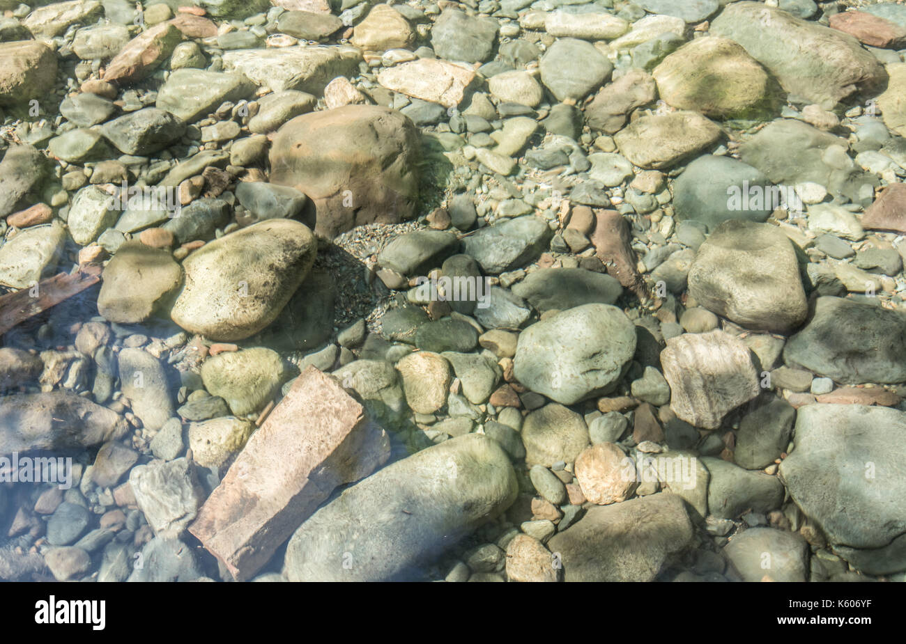 River Rocks Sit Below Clear Water in pacific northwest wilderness Stock Photo
