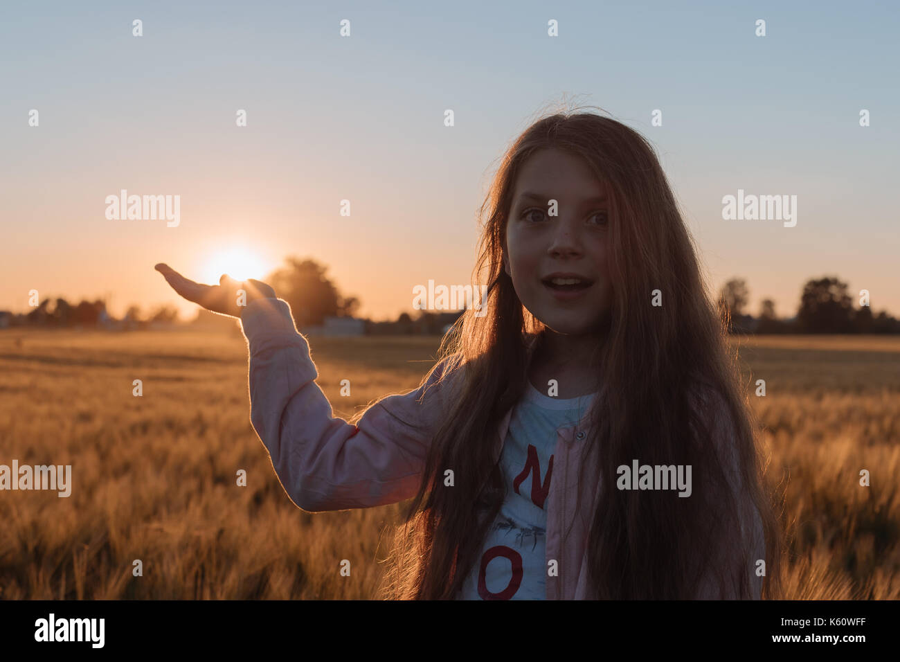 Girl teenager holds the sun with the palm of his hand. Stock Photo