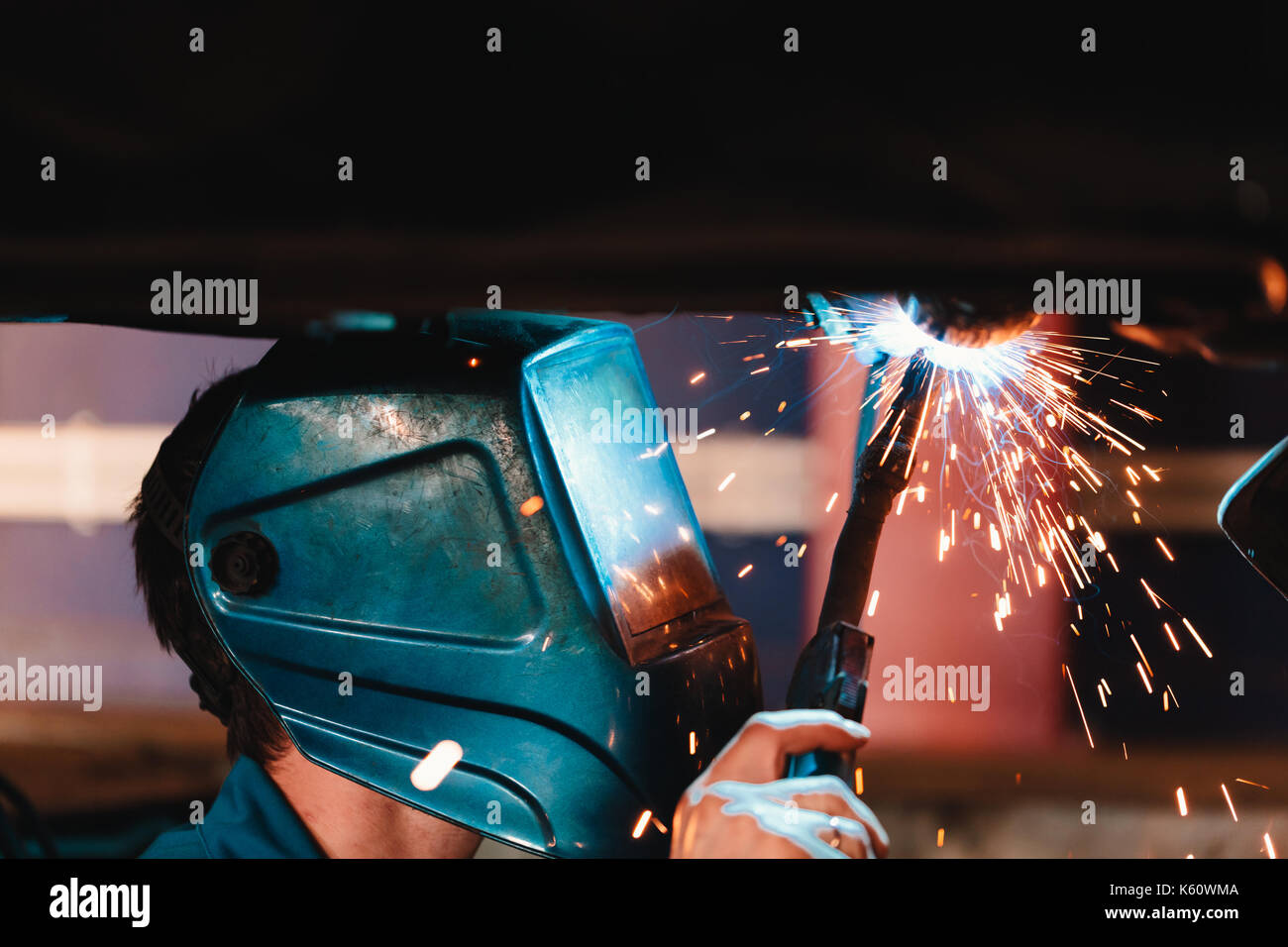 Man in a mask does welding machines. Stock Photo