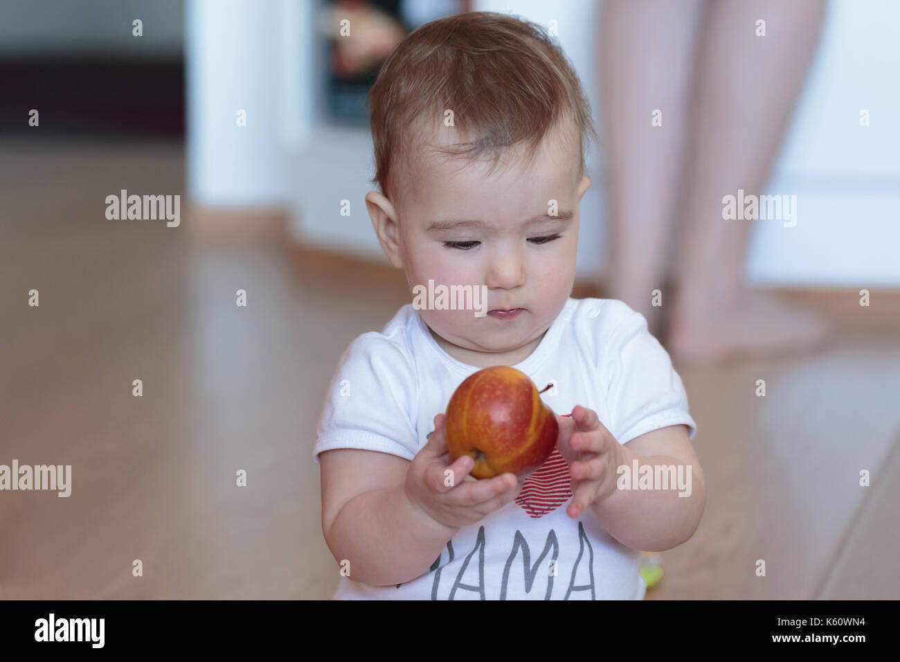 Little child with a red apple in his hands. Stock Photo