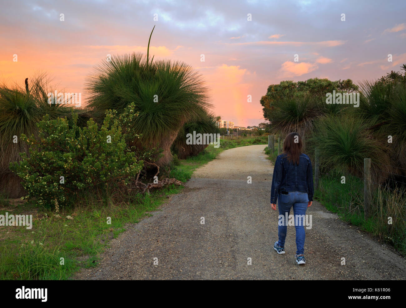 Woman walking down a path through Star Swamp Reserve suburban bushland Stock Photo
