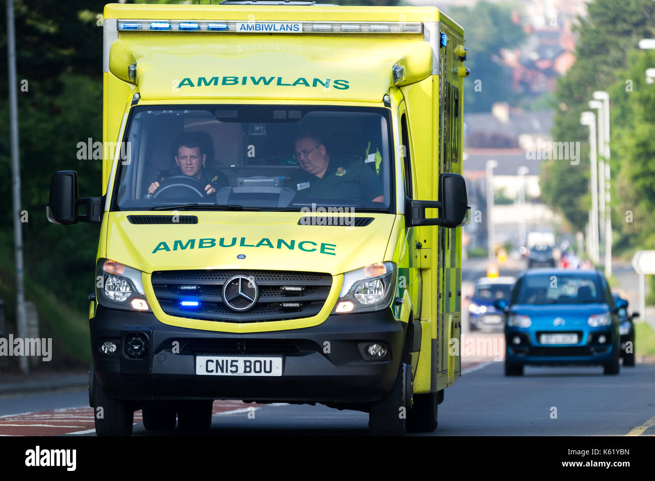 Close up of an Ambulance with flashing blue lights driving along the