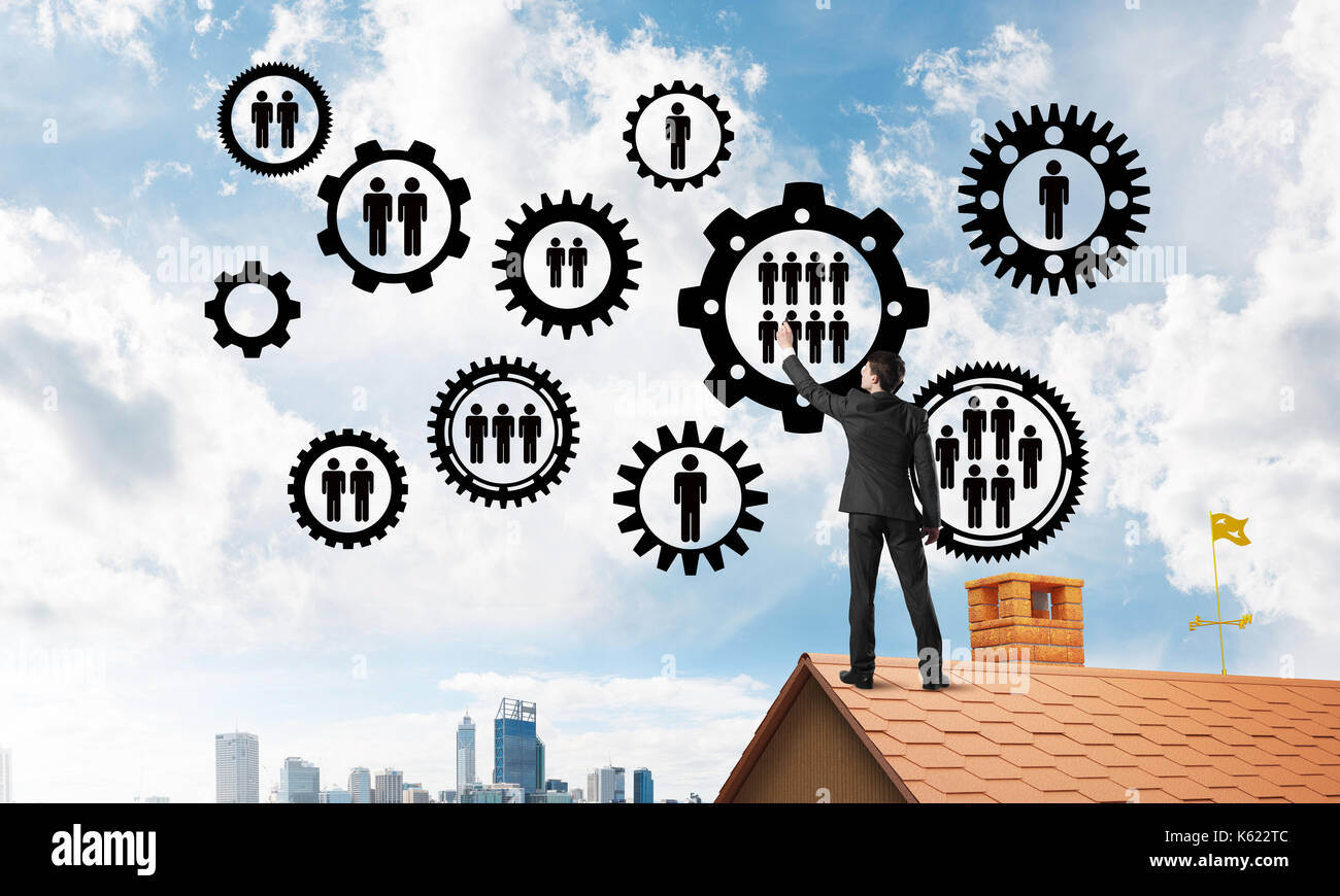 Businessman on house roof presenting teamwork and connection concept ...