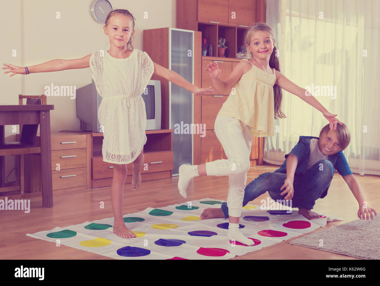 Group of happy children playing at twister in interior Stock Photo