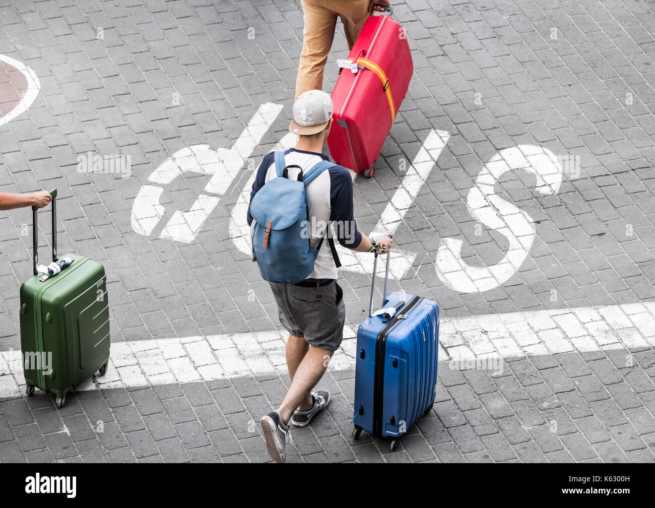 Tourists with wheeled suitcases. Stock Photo
