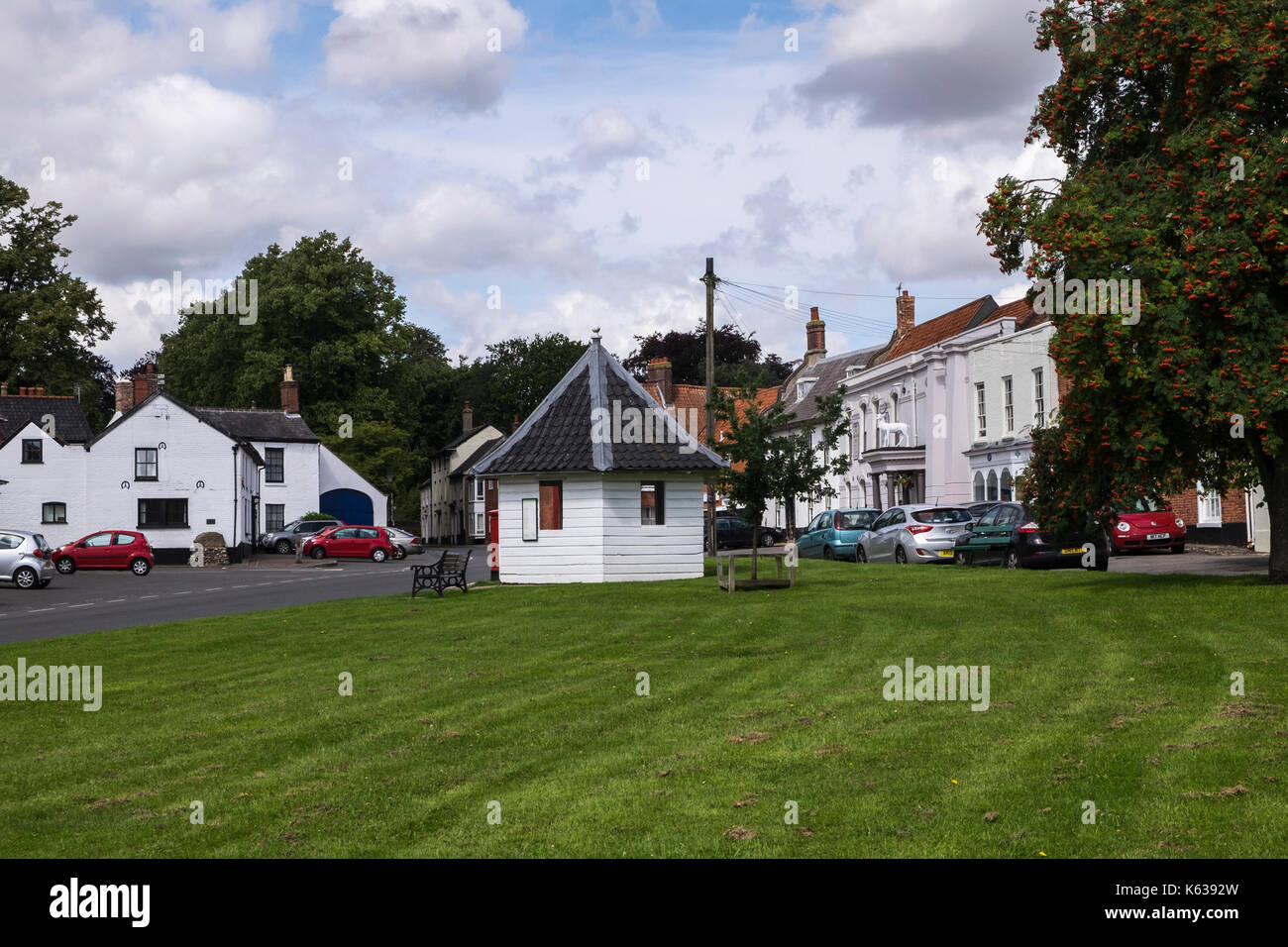 Hingham village green with the bus stop wooden shelter and the White Hart pub, hotel, Norfolk, England, UK Stock Photo