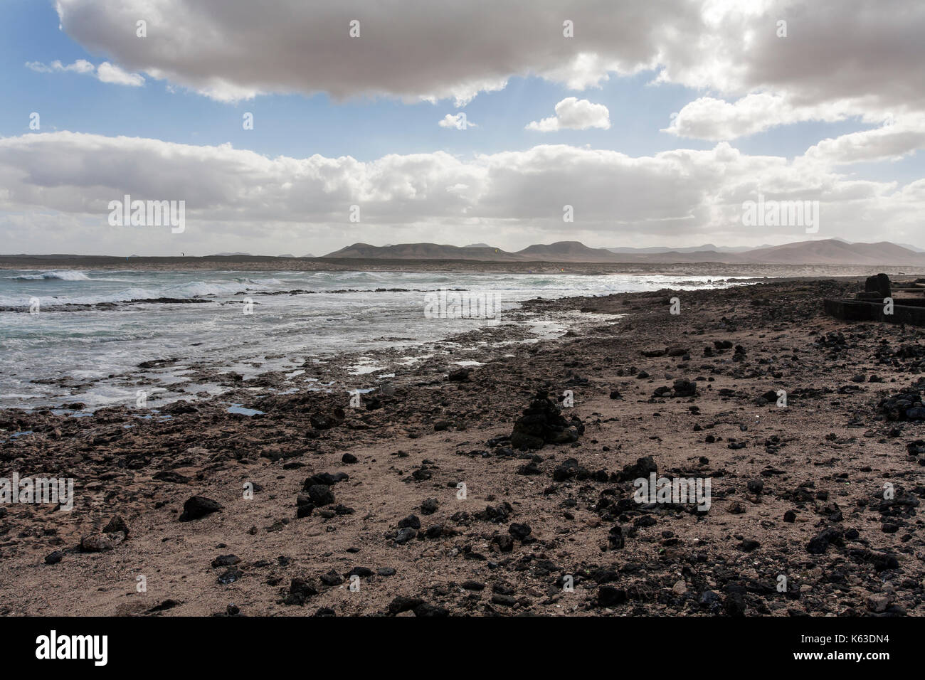 Dark landscape of ocean surf and rocks on a cloudy day on Fuerteventura Stock Photo