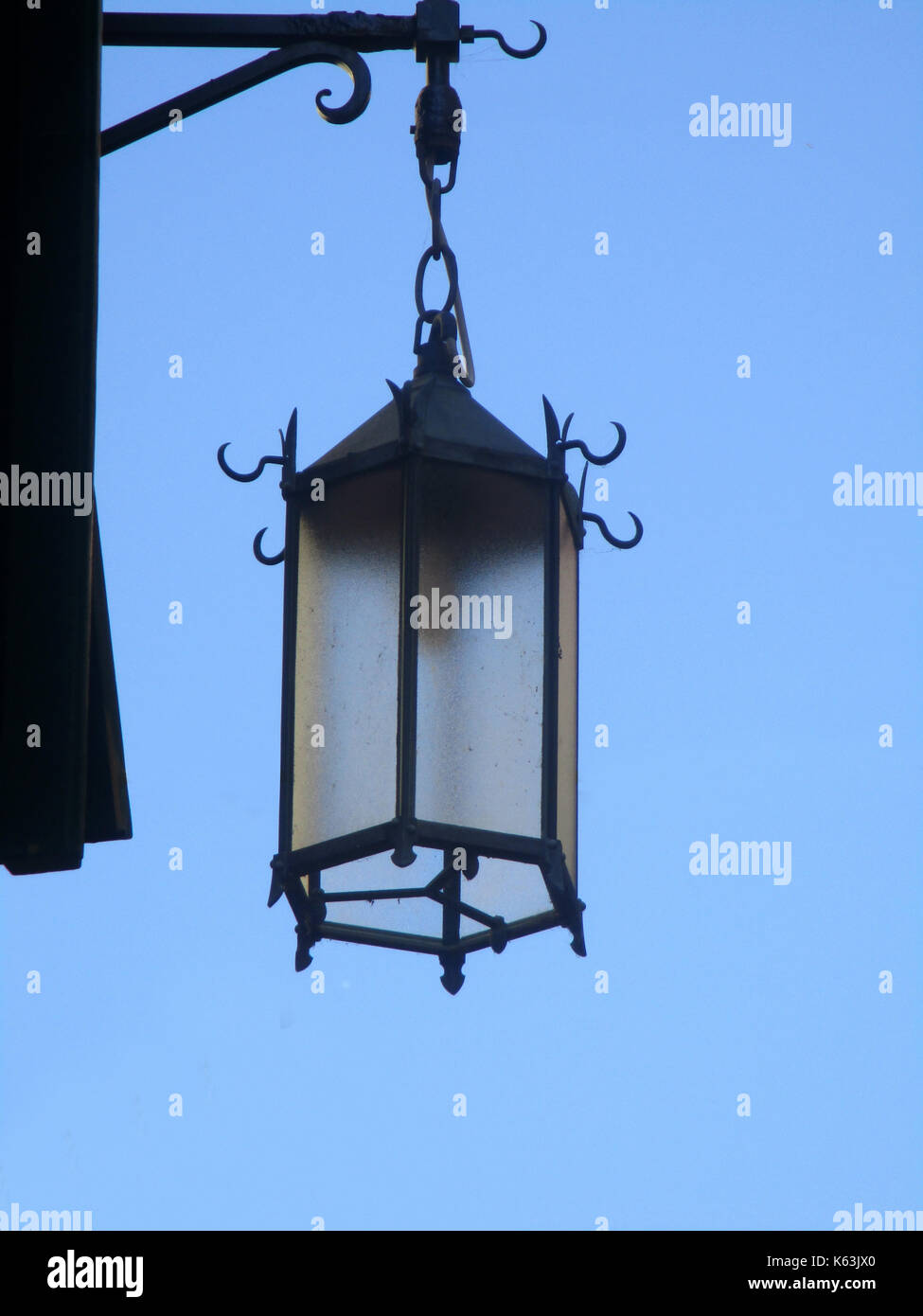 old wrought-iron street lamp, blue sky background Stock Photo - Alamy
