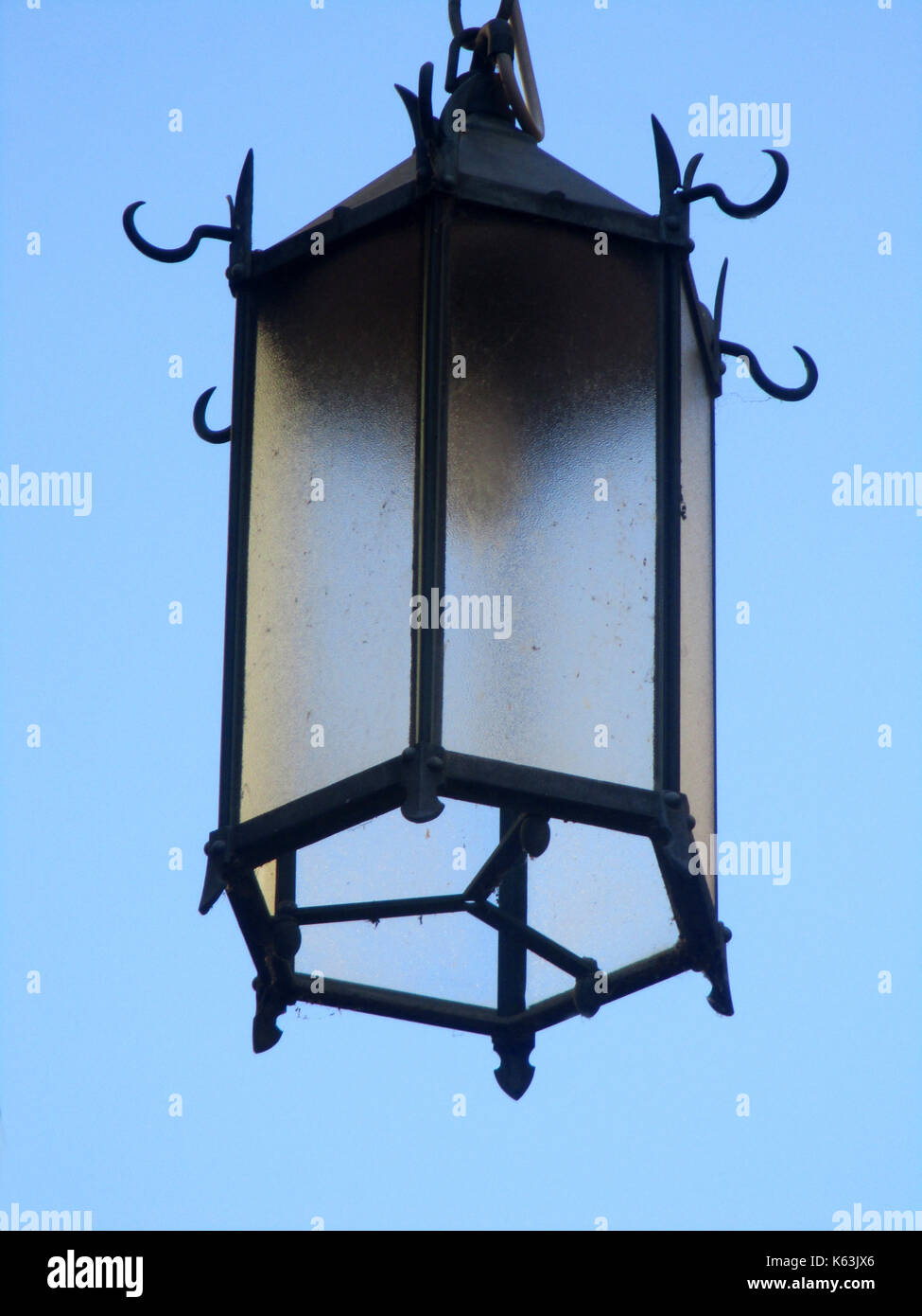 old wrought-iron street lamp, blue sky background Stock Photo - Alamy