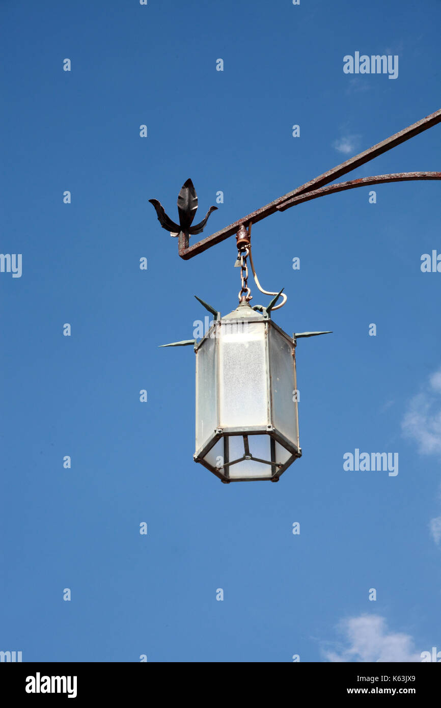 old wrought-iron street lamp, blue sky background Stock Photo - Alamy