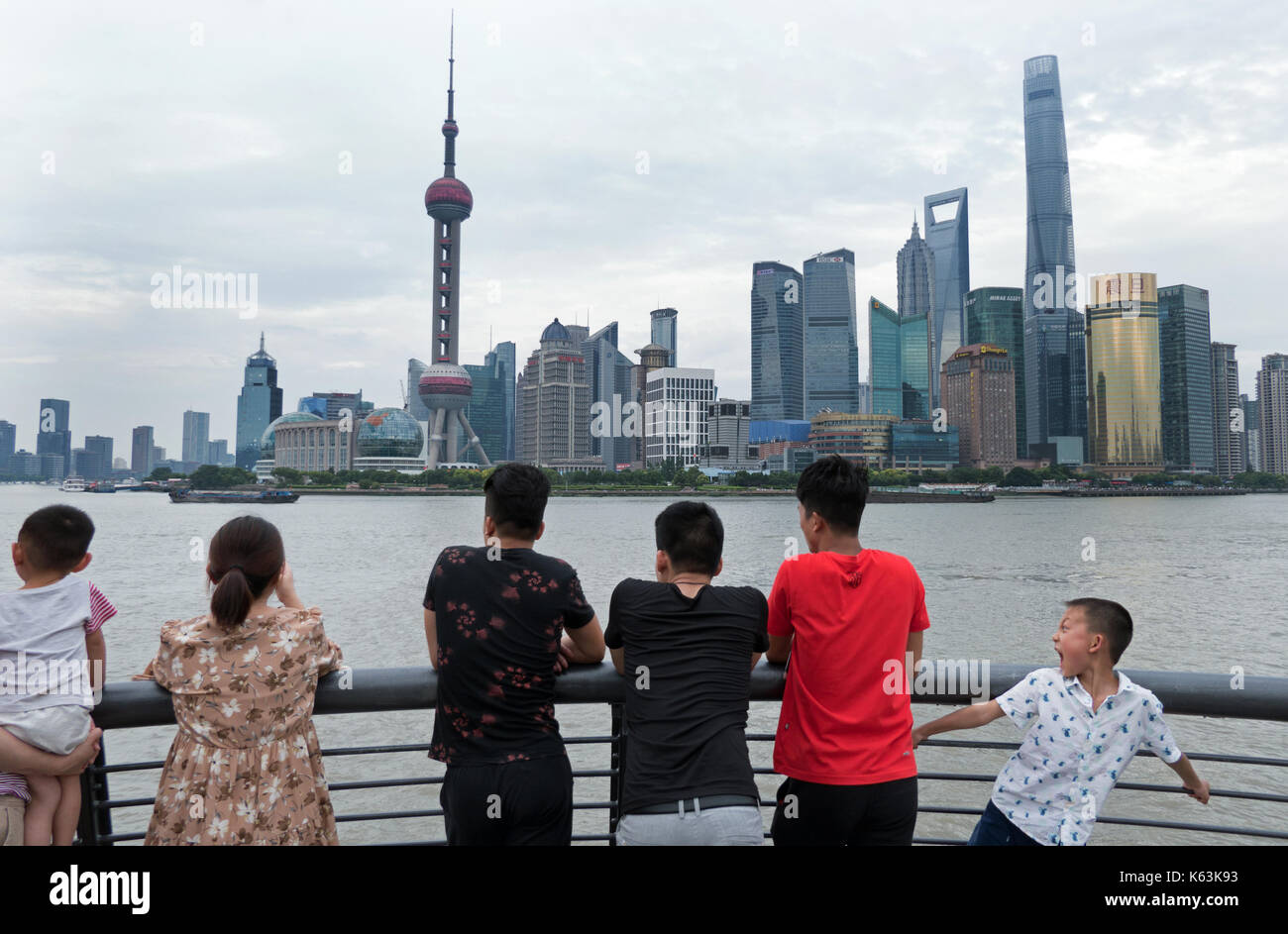 People and tourists watching the Bund of Shanghai, China, Asia with Huangpu River. Landscape in Chinese city with skyline, modern buildings, skyscrape Stock Photo
