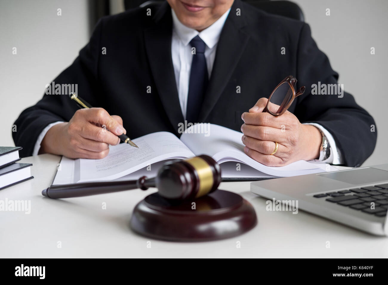 lawyer hand writes the document in court (justice, law) with sounding ...