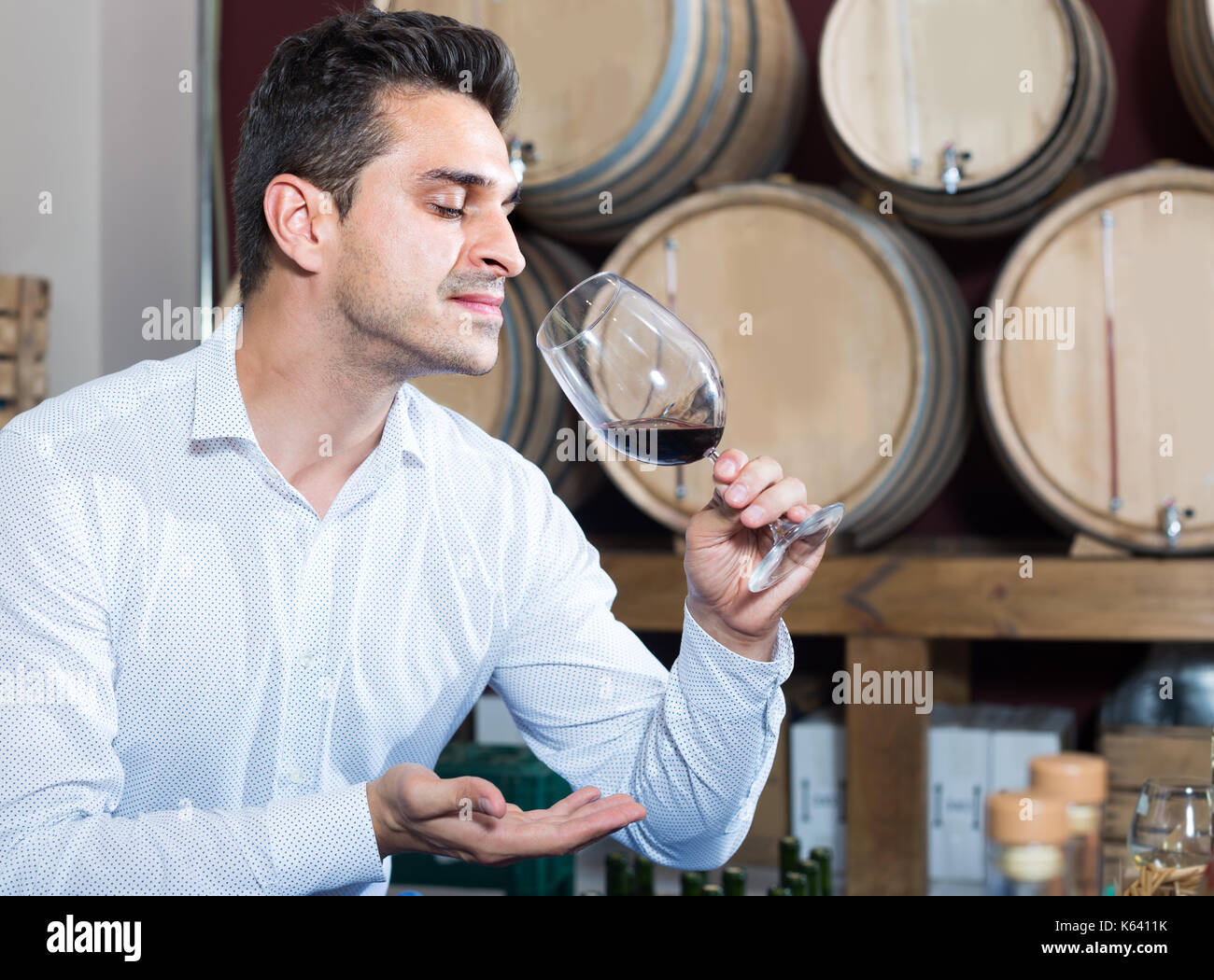 positive latino man having wine tasting in cellar with woods Stock ...
